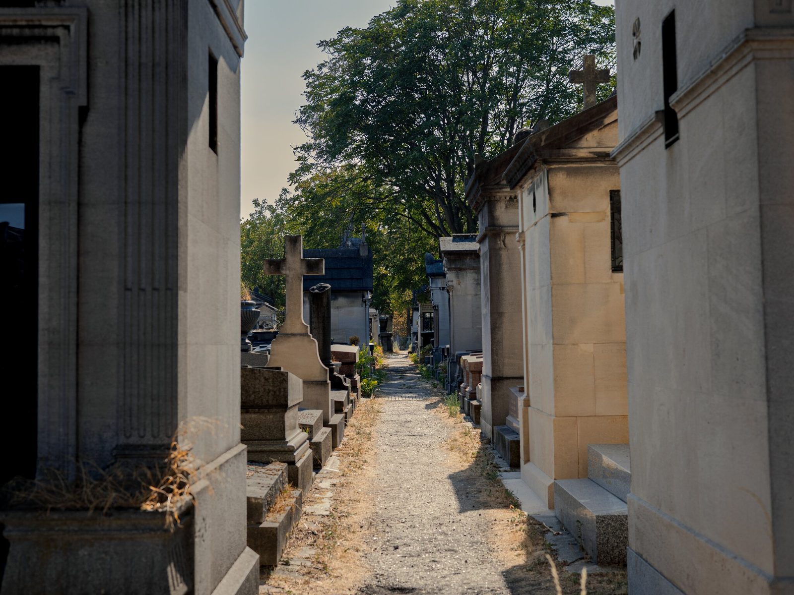 A narrow gravel path running between family vaults away from the main avenues