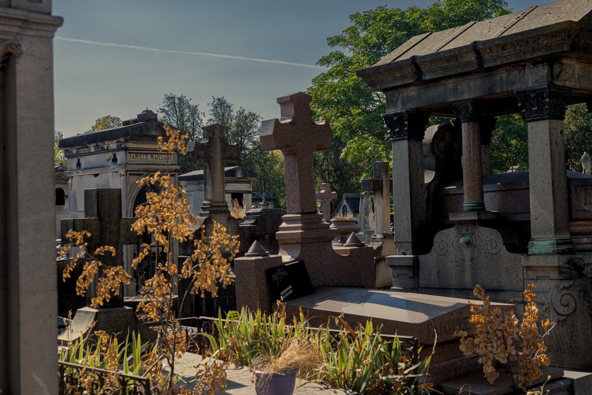 Family vaults and a stone cross among dried grasses in late summer